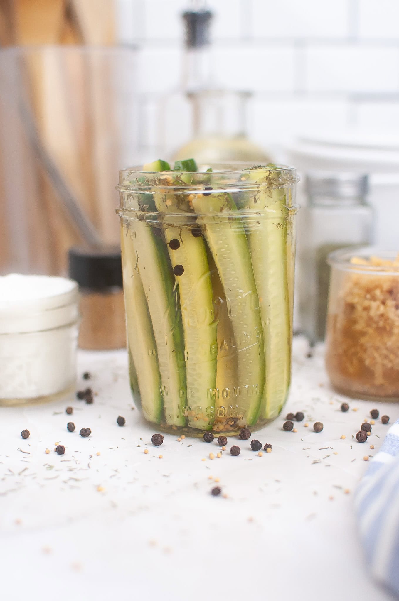 Head on photo of dill pickle spears in a glass jar.