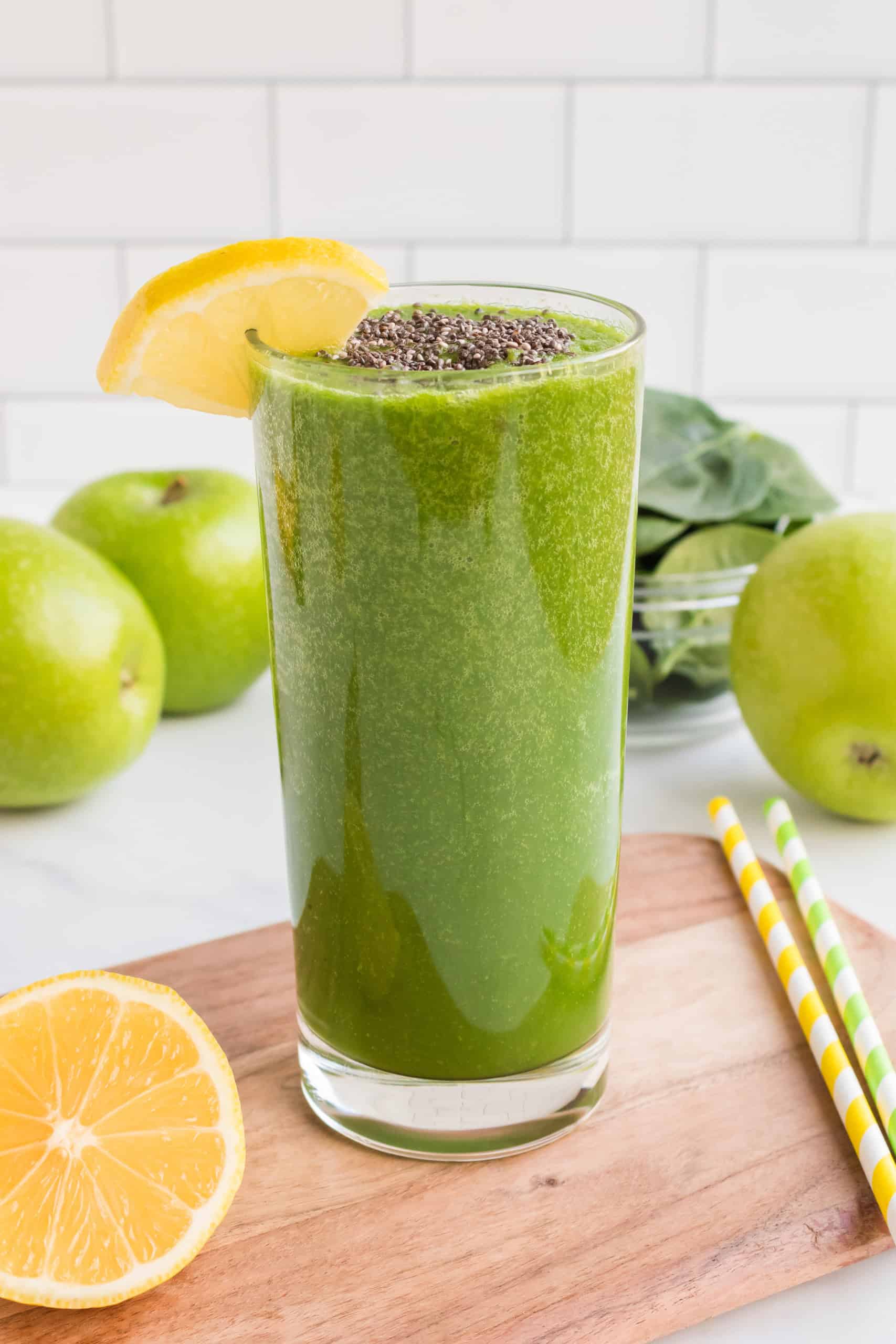 Green apple smothie with chia seeds and a lemon wedge on the side.