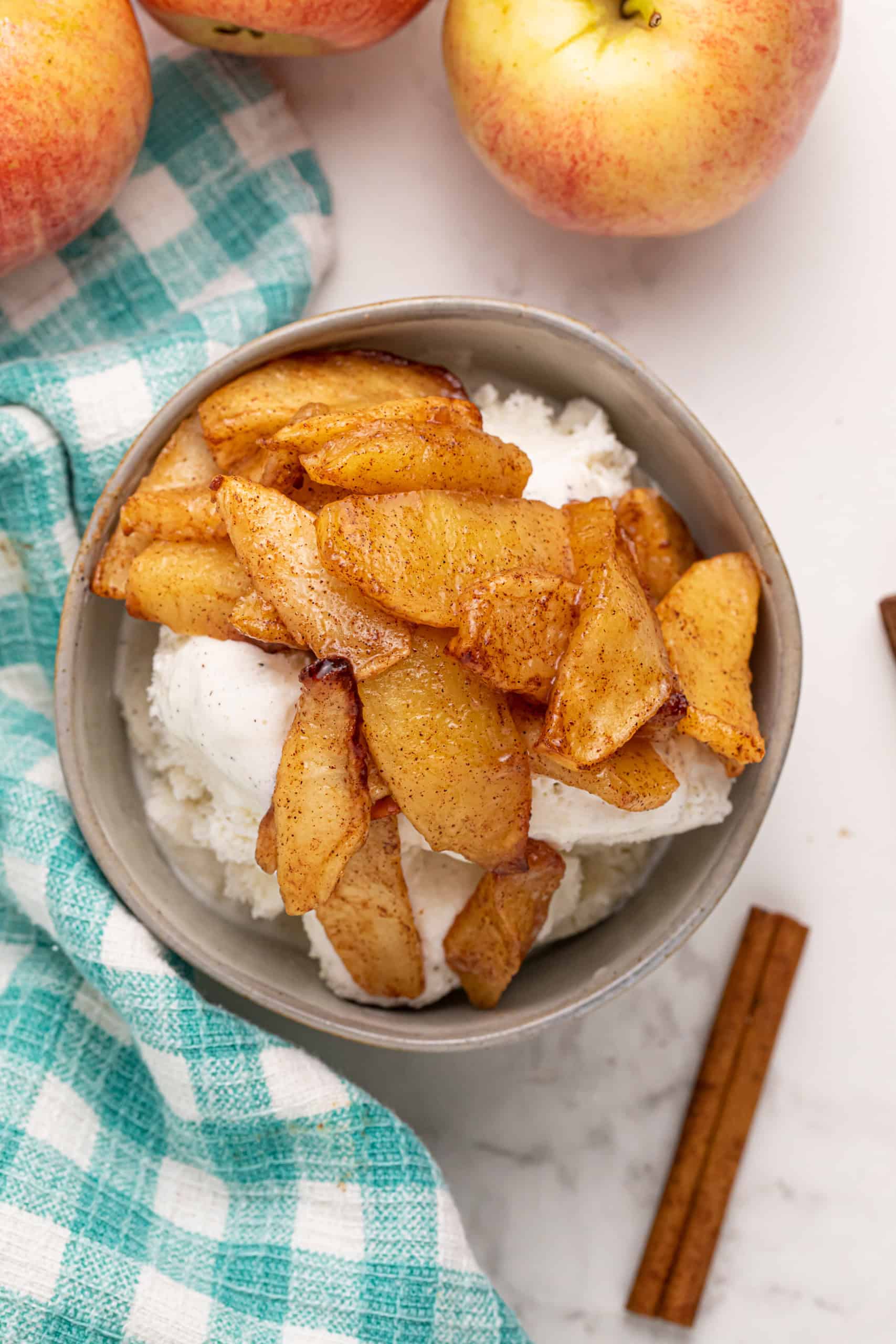 Overhead view of fried apples with cinnamon and sugar over vanilla ice cream.