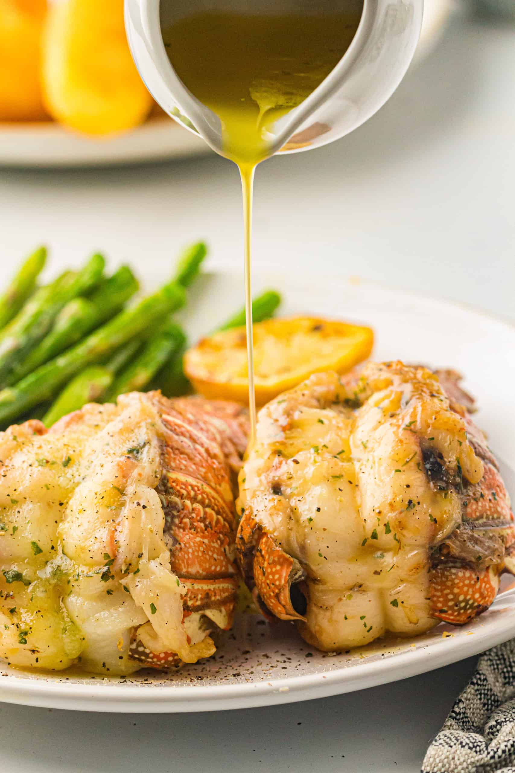 Pouring butter on lobster tails.