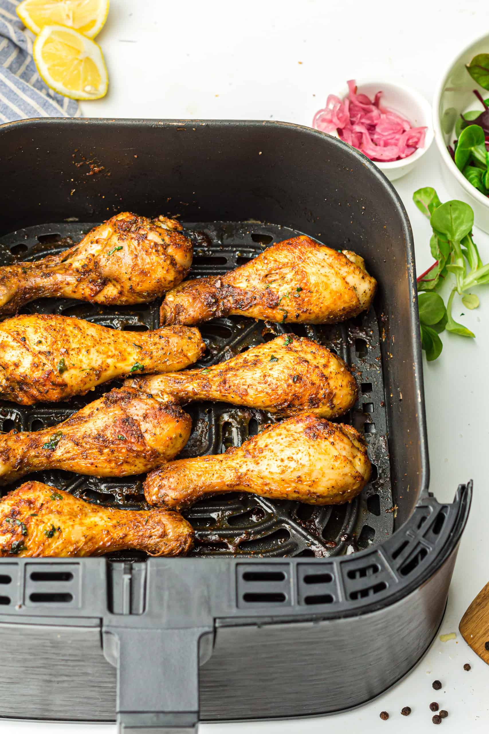 Overhead view of drumsticks in air fryer basket.