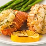 Air Fryer Lobster tails with asparagus on a white plate.
