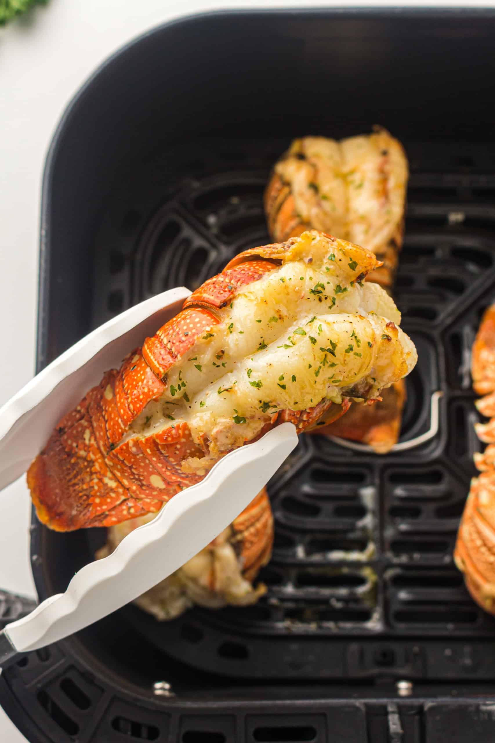 Picking up lobster tail with tongs.