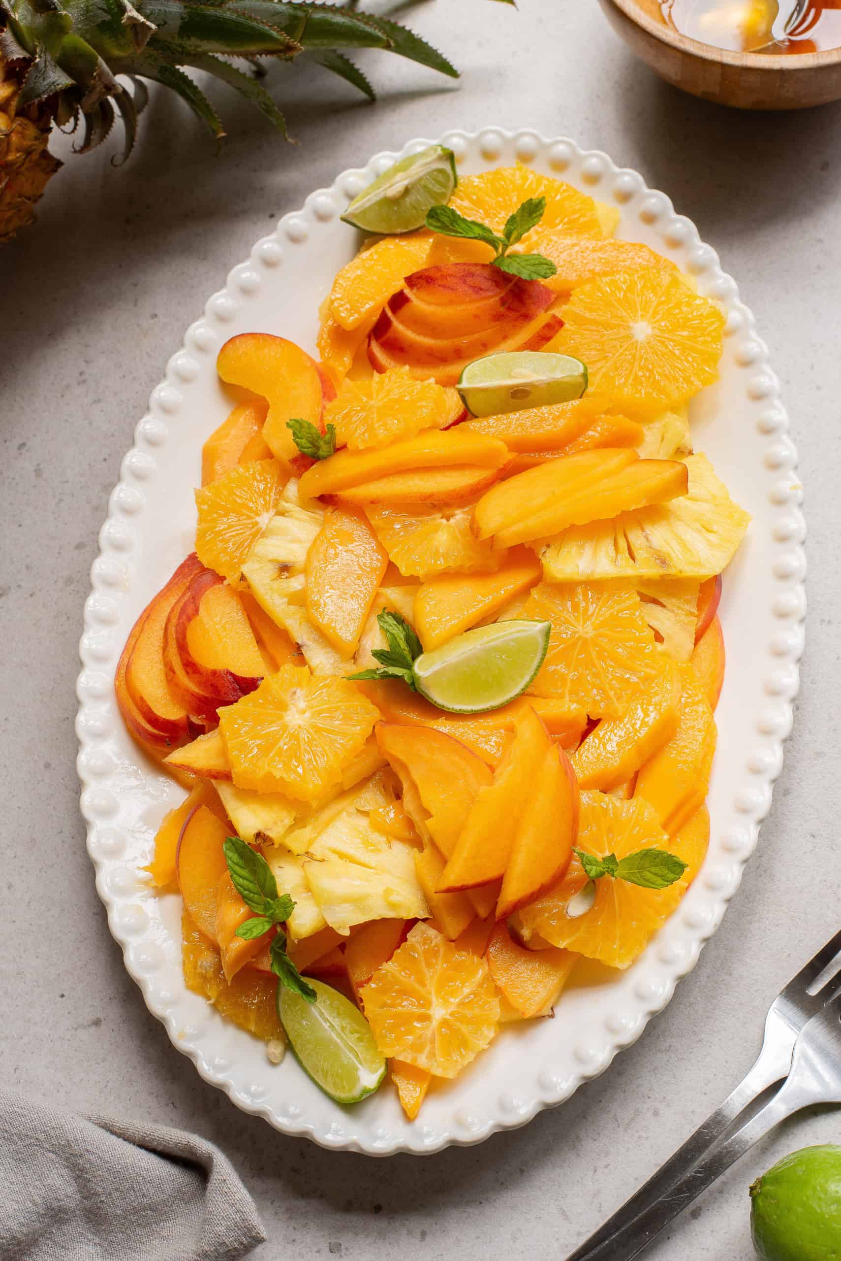 Overhead view or summer orange, peach, mango, pieapple salad.