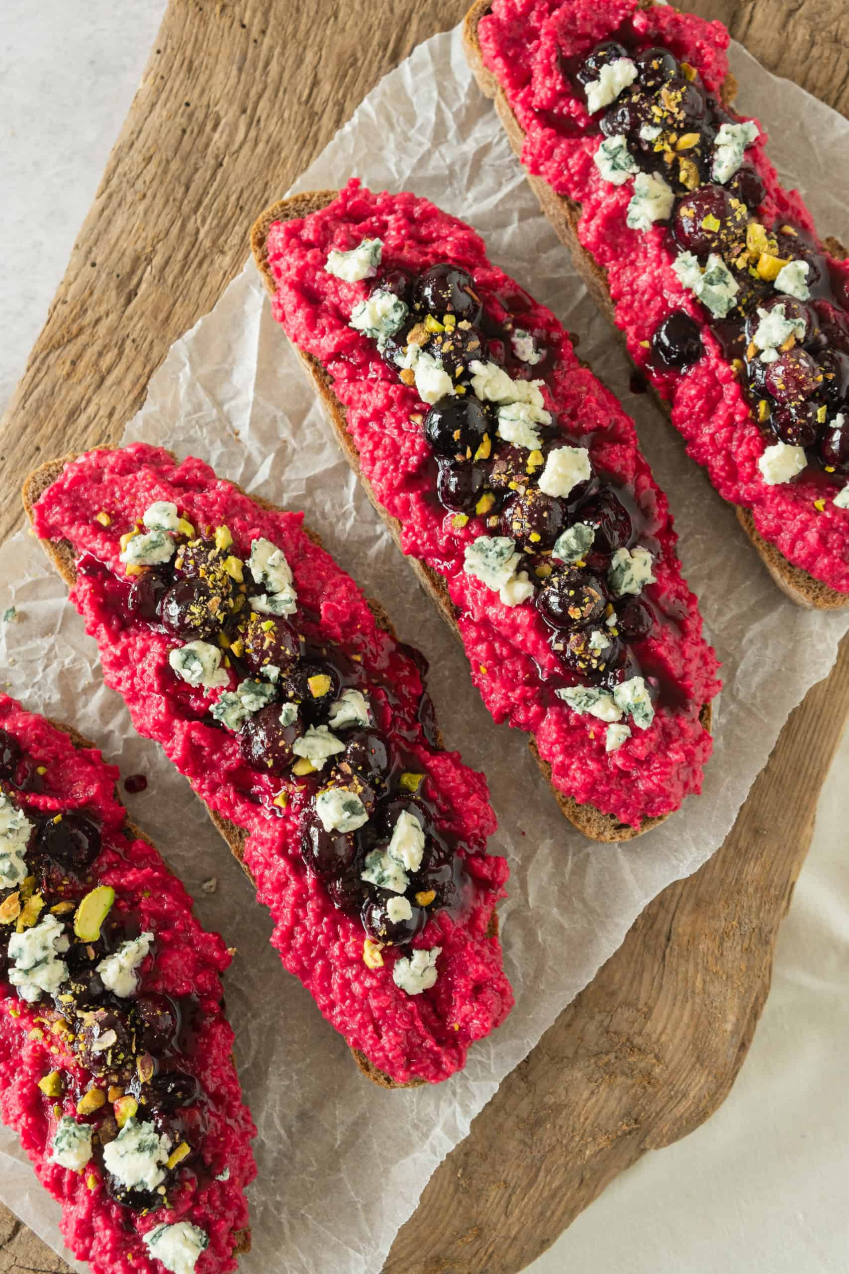 Overhead view of beetroot hummus toast on a cutting board.