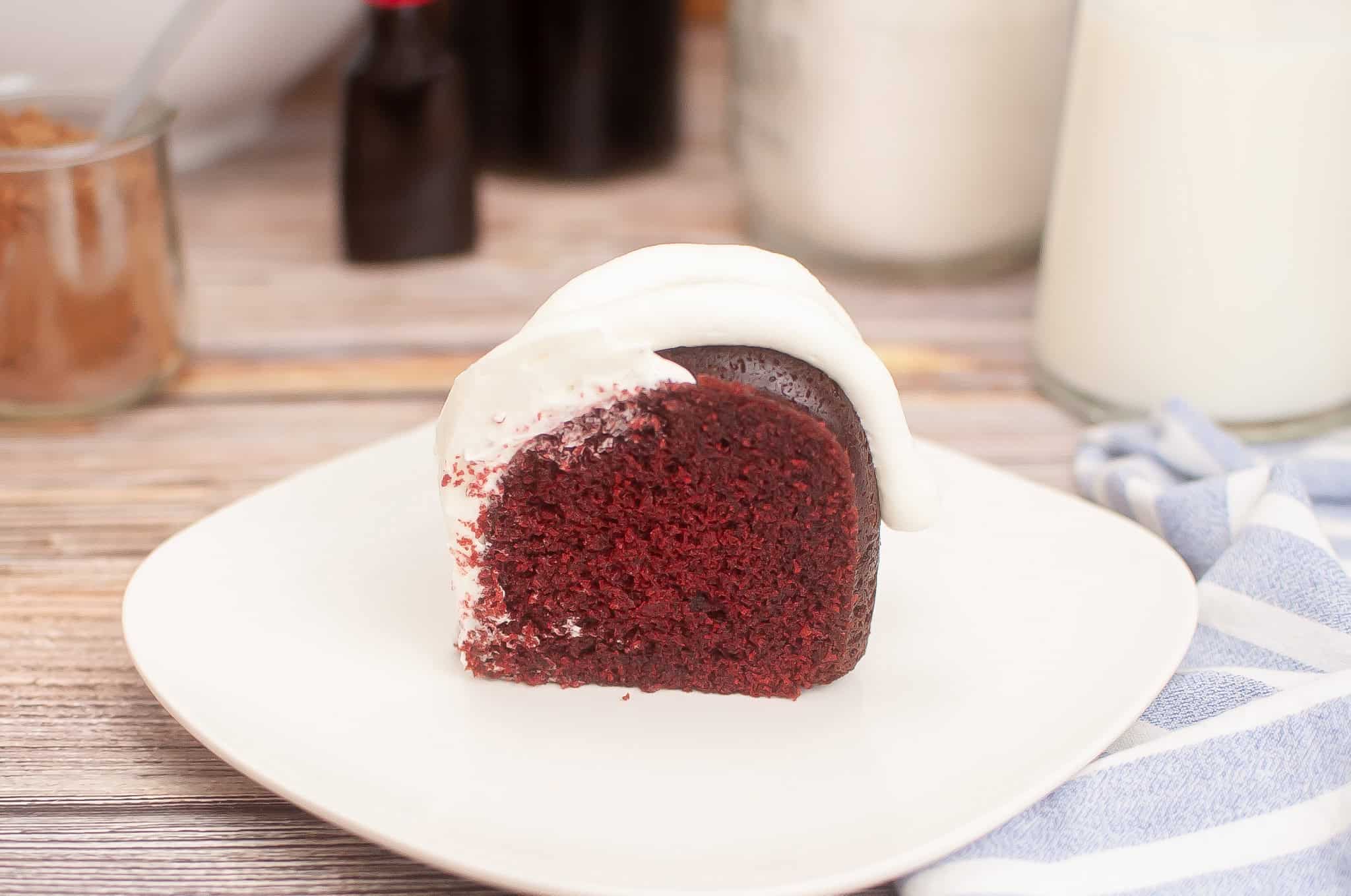 Slice of red velvet cake on a white plate.
