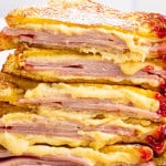 Monte cristo sandwiches cut in half with melty cheese and raspberry preserves dripping down the side.
