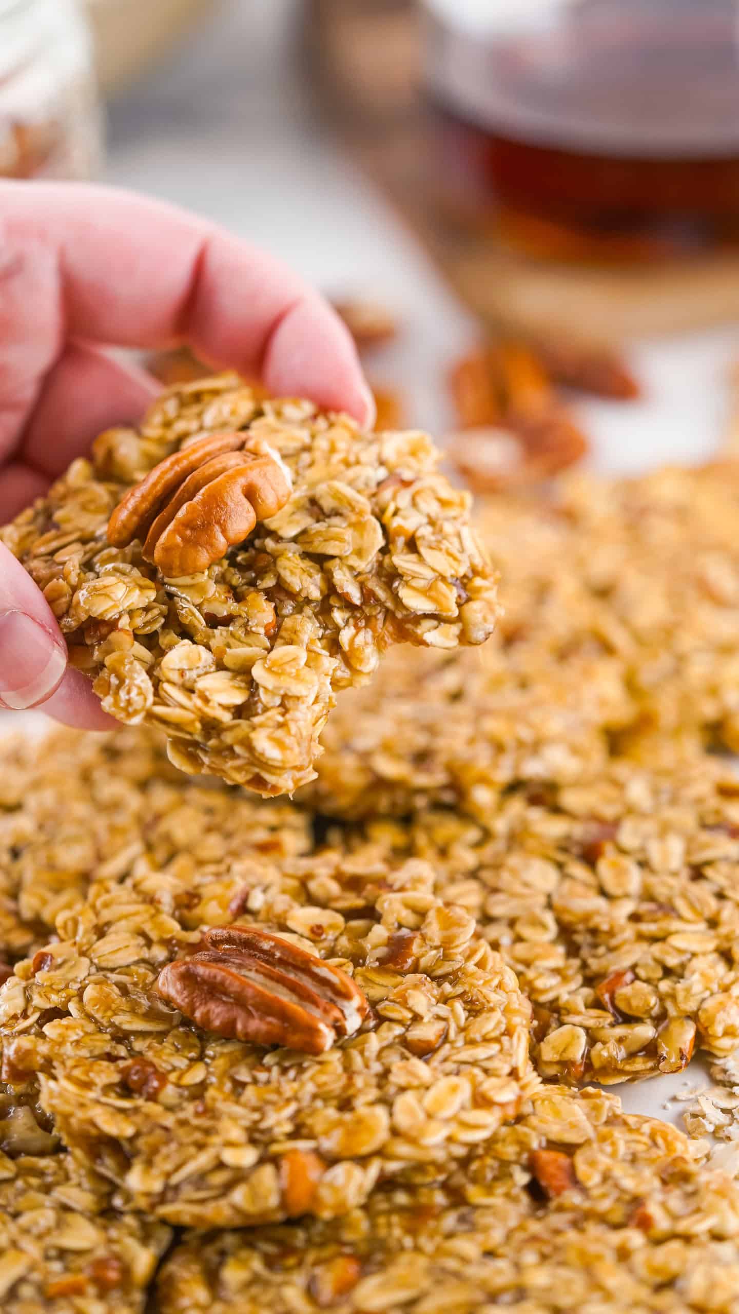 Holding a no-bake maple pecan cookie with a bite out of it.