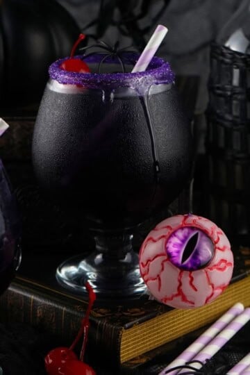 purple people eater drink with a straw and cherry in it