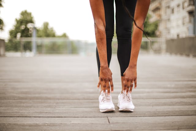 Woman bending over stretching for a run.