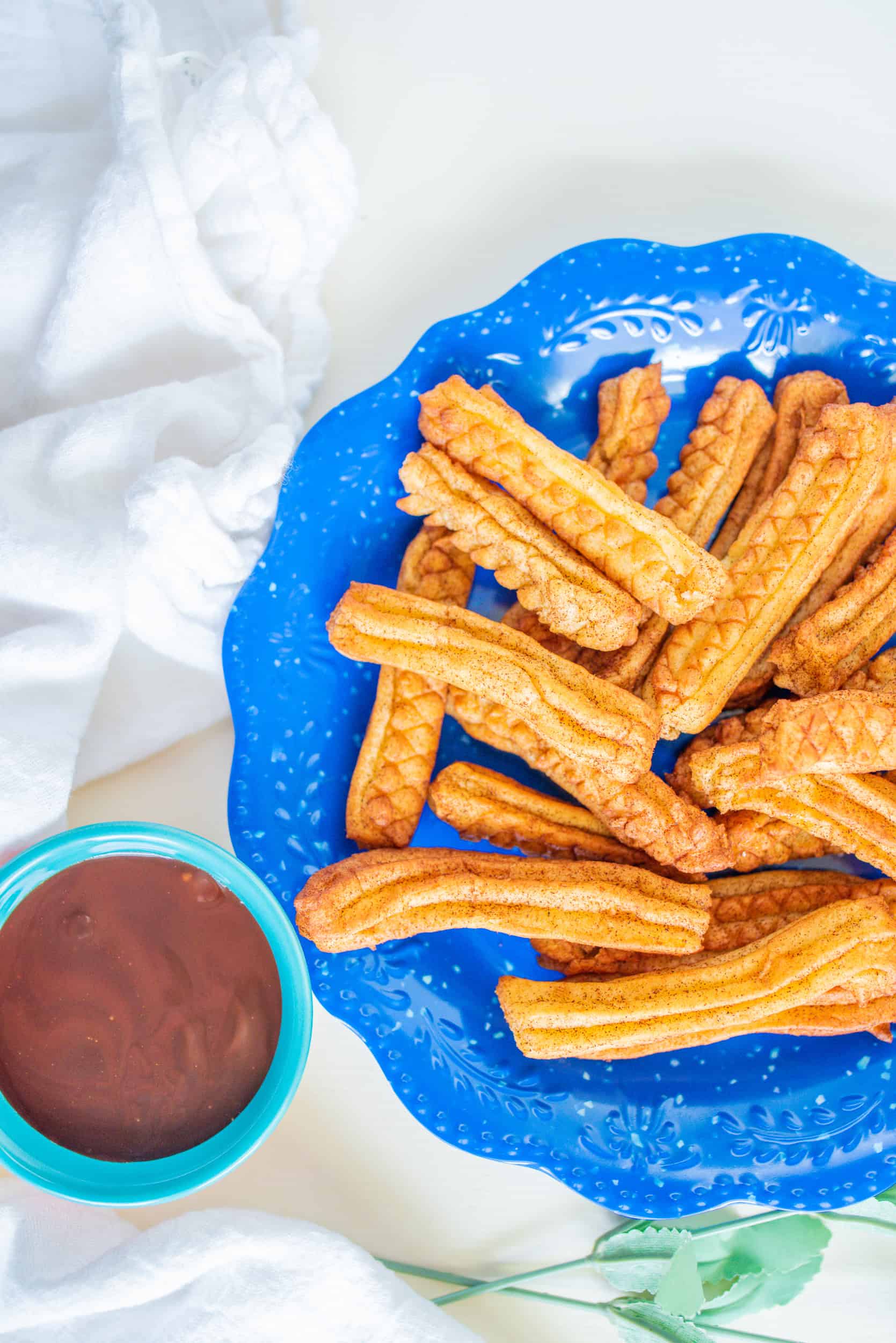 Overhead view of air churros on a blue plate.
