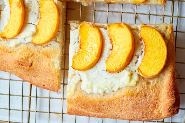 Overhead view of slices of peach ricotta pizza.