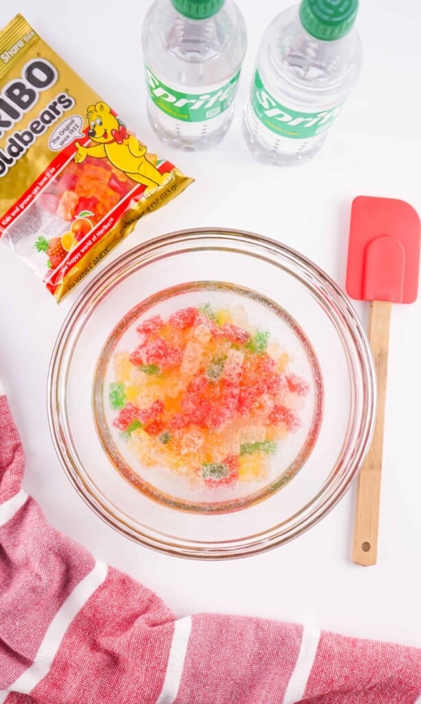 Overhead view of Gummy Bears soaking in Sprite in a mixing bowl