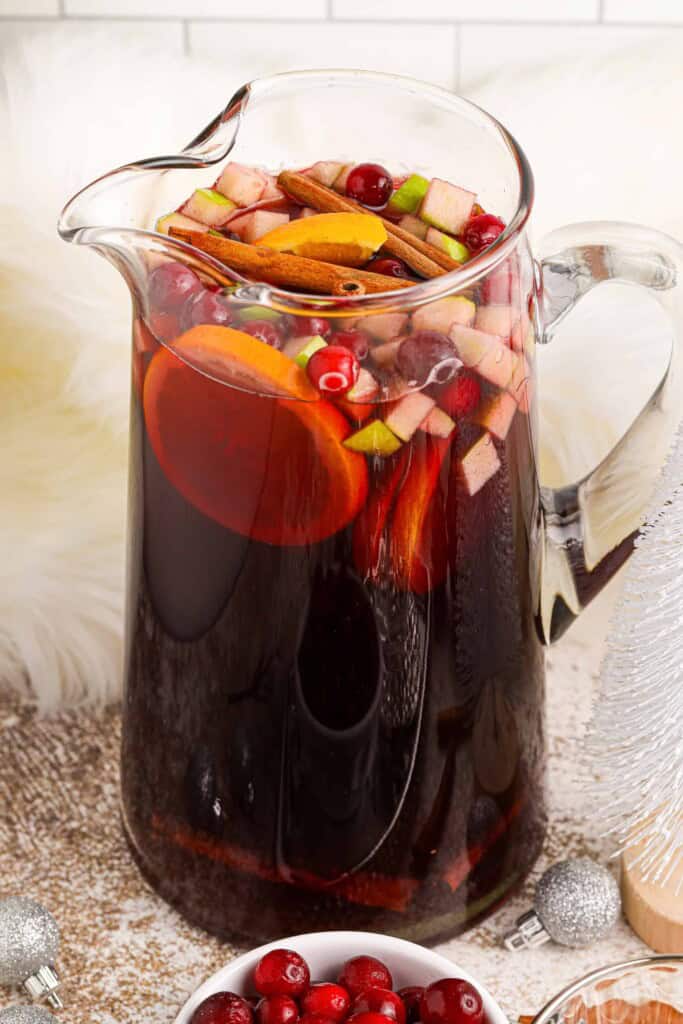 Glass pitcher filled with Holiday Sangria.