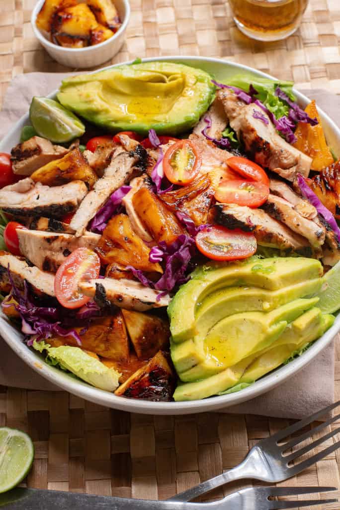 Overhead view of chicken avocado salad with grilled pineapple and honey lime dressing.