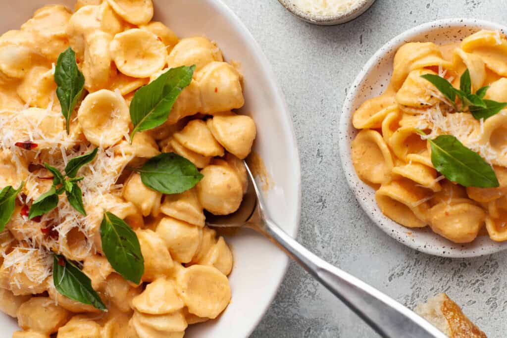 Overhead view of pasta with vodka sauce being served.