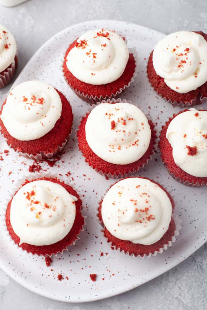 Overehead view of red velvet cupcakes with cream cheese frosting.