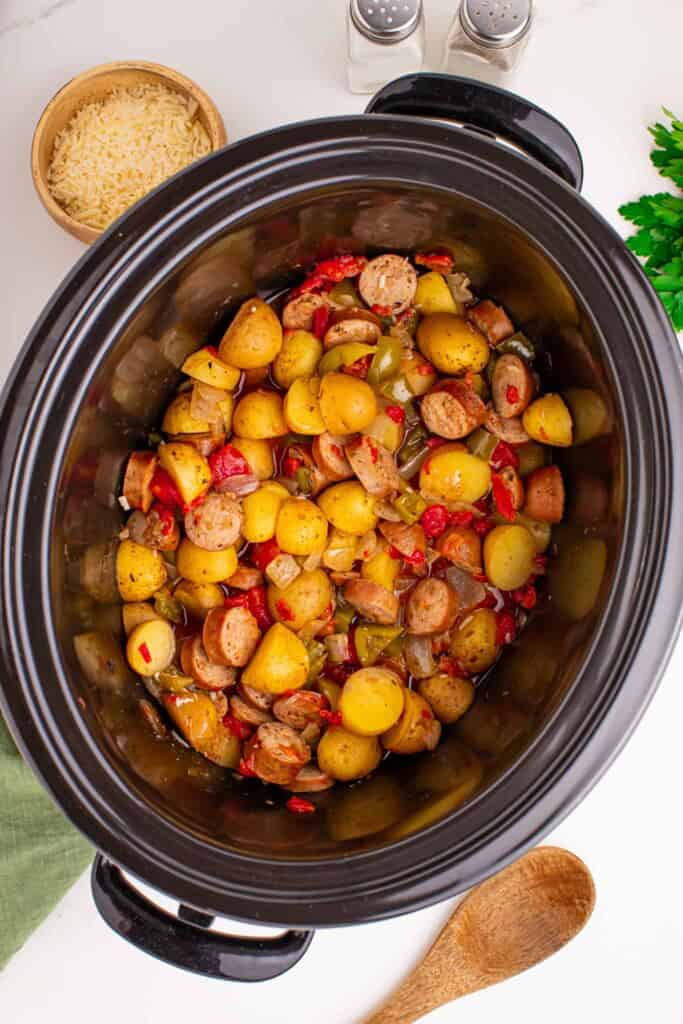Overhead view of sausage and potatoes in crockpot.