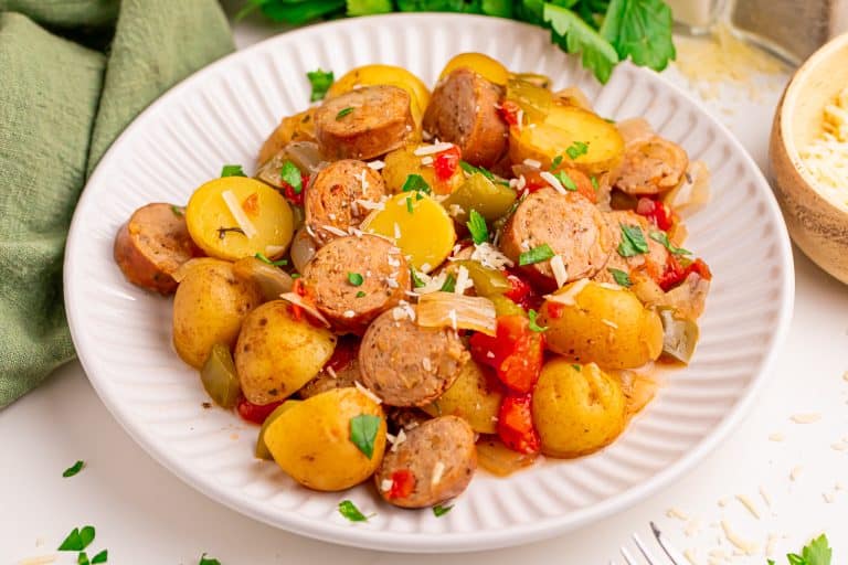 Potatoes and sausage on a white plate.