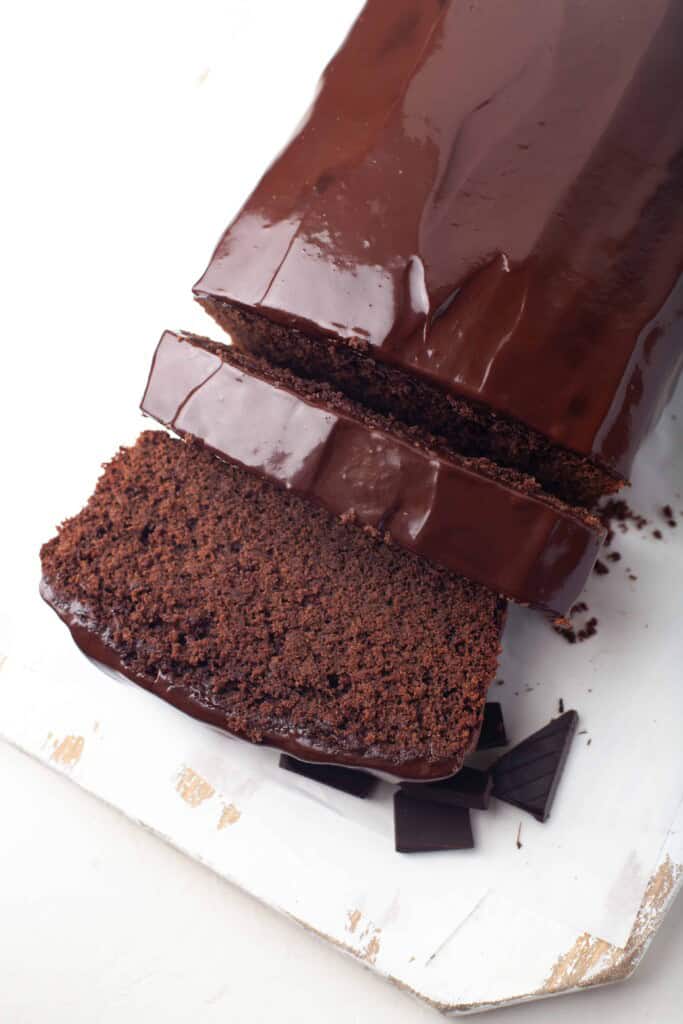 Overhead view of sliced chocolate cake with ganache.