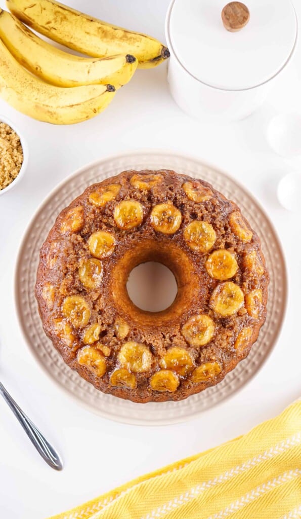 Overhead view of upside down banana cake on a glass plate.
