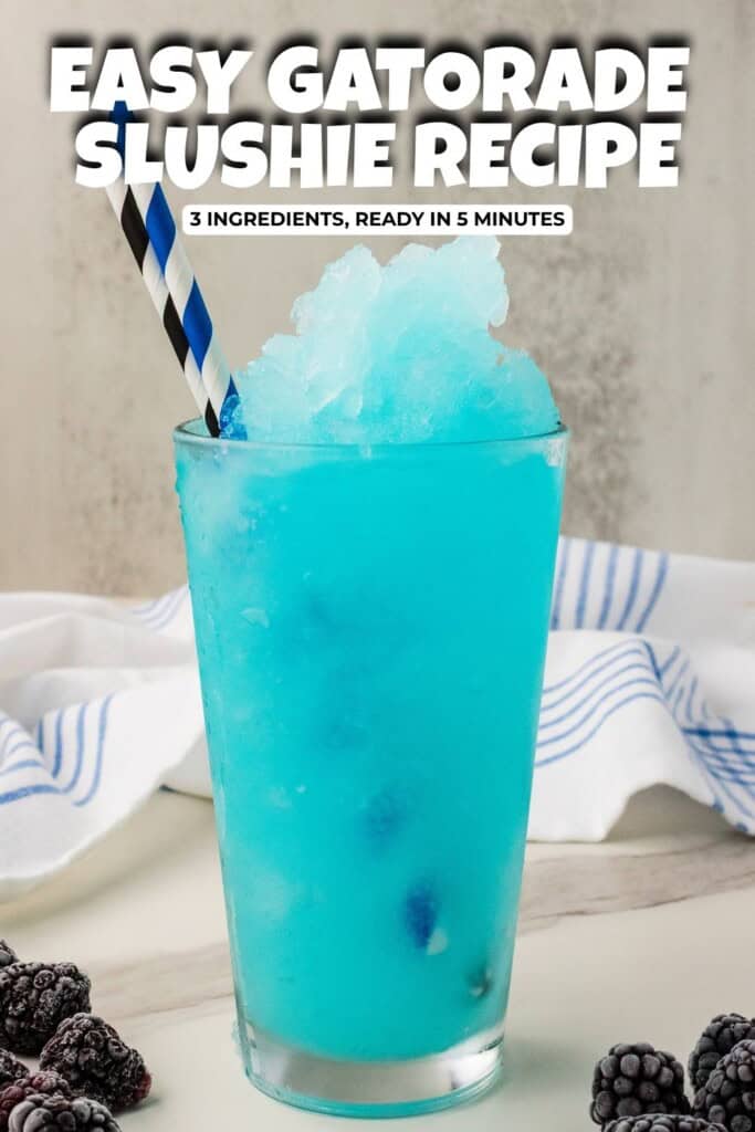 Blue Gatorade slushie in tall glass with 2 straws.