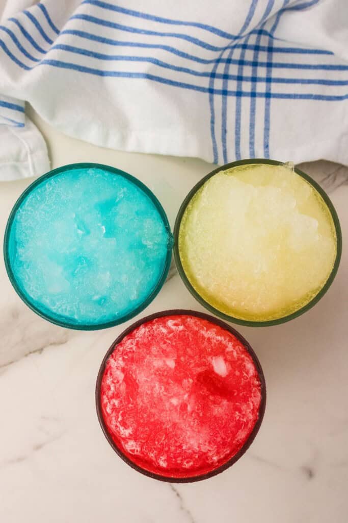 Overhead view of three Gatorade slushie flavors with striped towel"