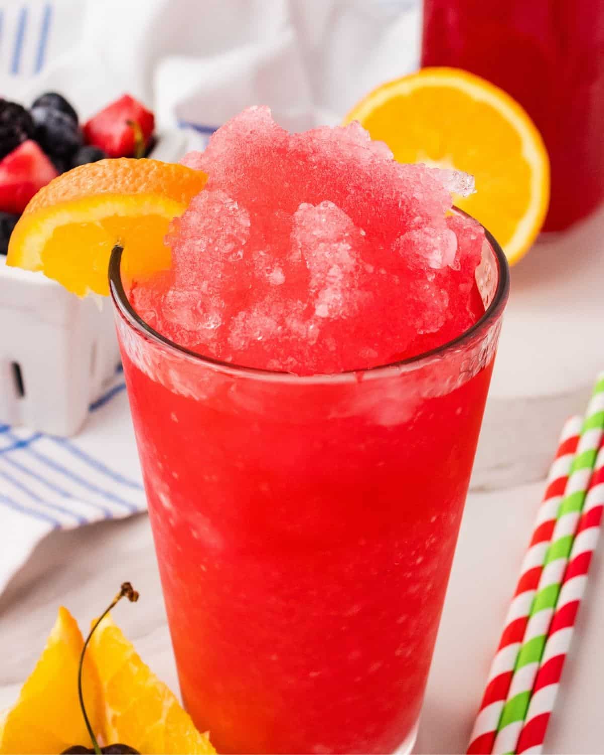 Hawaiian Punch slushie topped with crushed ice and an orange wedge