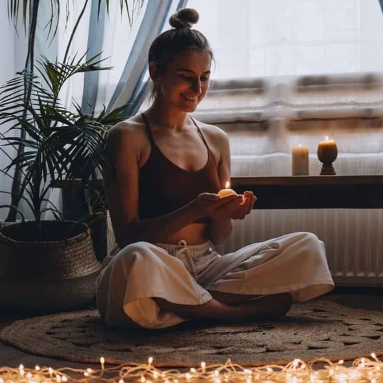 Young lady meditating with candle.