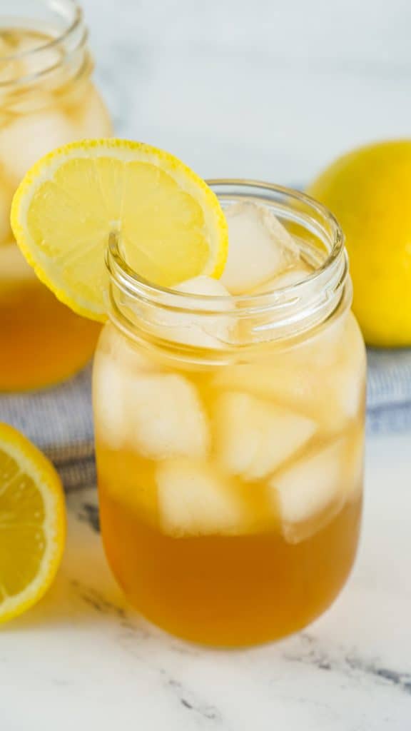 Arnold Palmer Cocktail in a Mason Jar glass filled with ice with a lemon slice garnish.