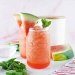 Head on view of watermelon Agua Fresca with a sprig of mint and watermelon slice for garnish.