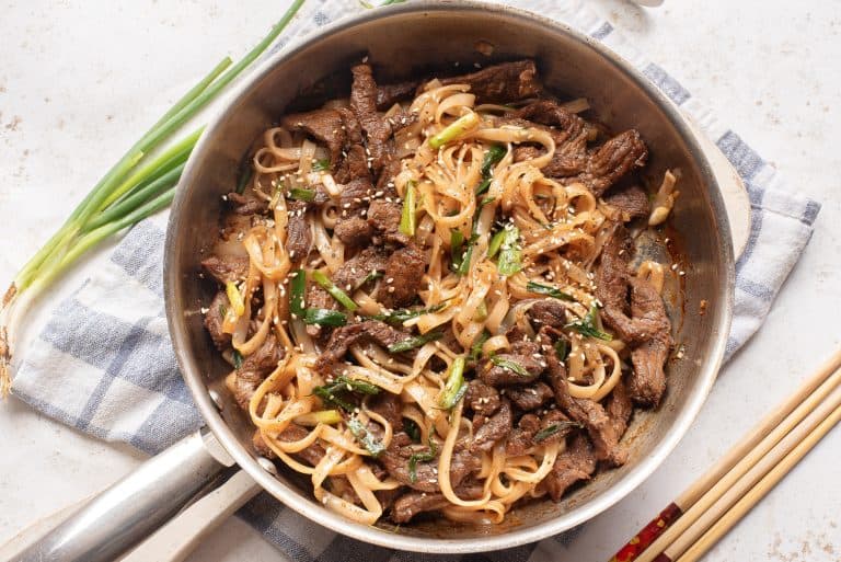 Overhead view of beef chow main in a skillet.