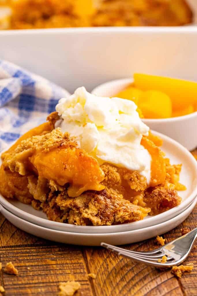 Headon view of peach dump cobbler with vanilla ice cream.