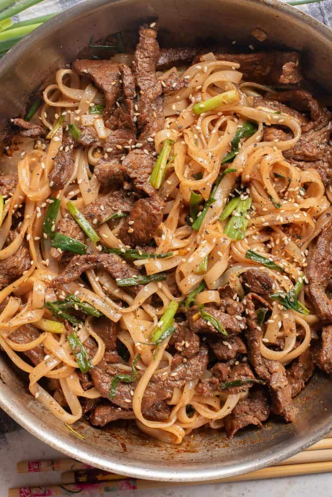 Overhead view of beef chow main in a skillet.