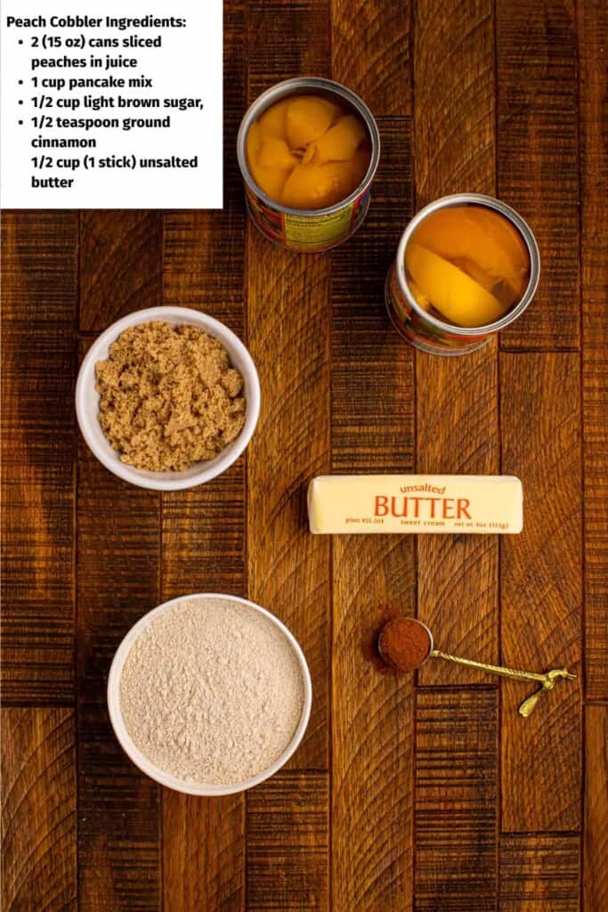 Overhead view of canned peaches, bowl of brown sugar, stick of butter and cup of pancake mix.