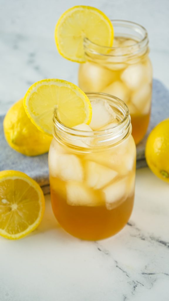 Two Arnold Palmer Cocktails in Mason jars with ice.