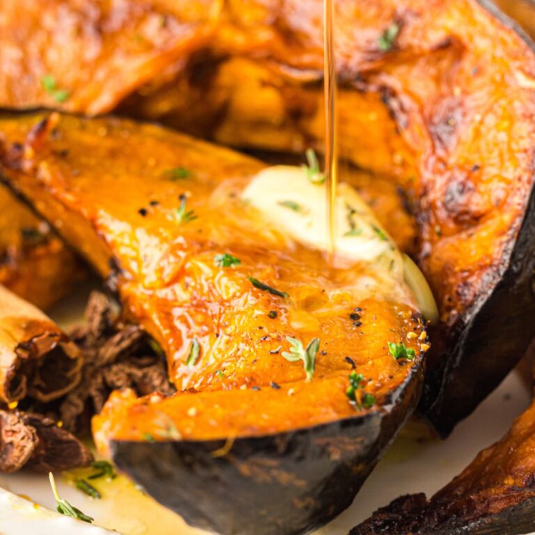 Closeup of air fryer pumpkin slices with butter and maple syrup.