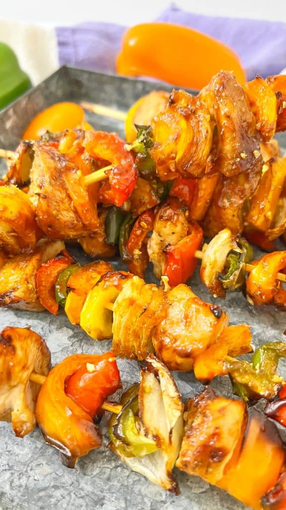 Overhead view of grilled chicken kabobs with BBQ sauce.