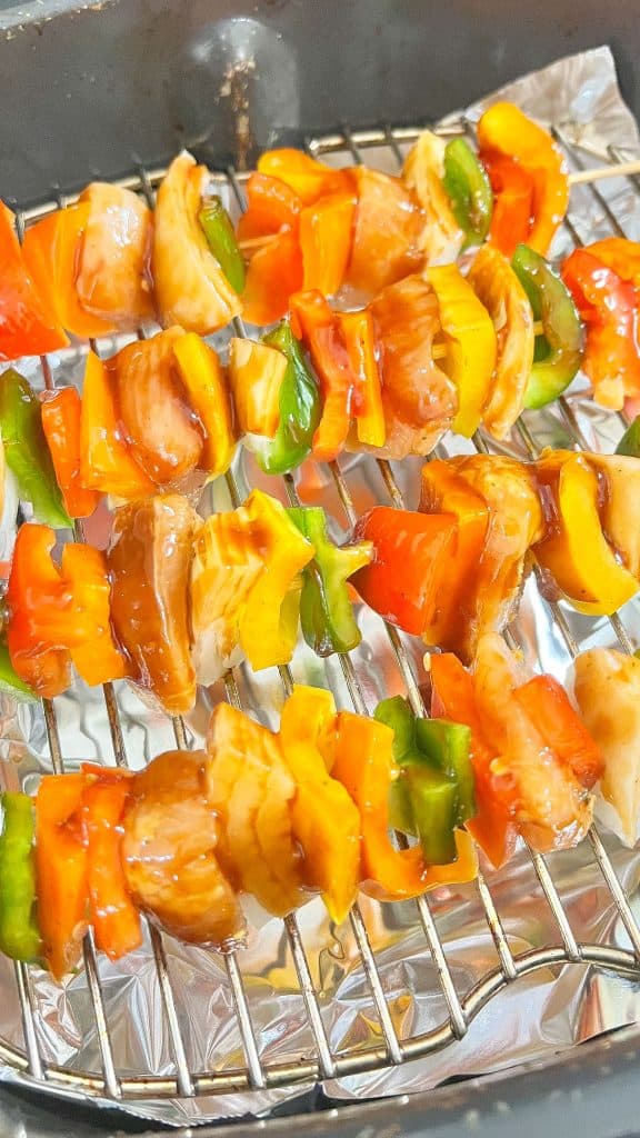 Overhead view of BBQ Chicken, onion and bell pepper kabobs on the grill.
