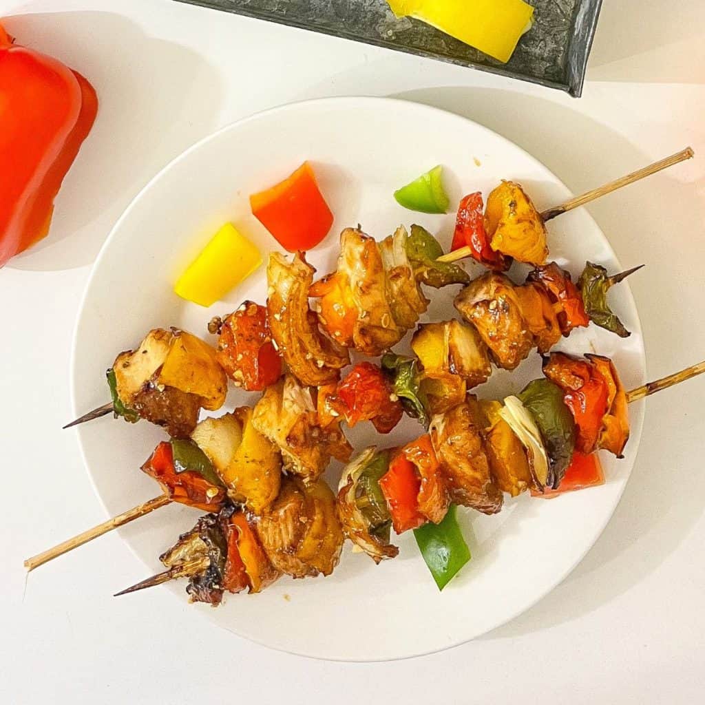 Overhead view of grilled chicken kabobs with bell peppers.