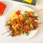Overhead view of grilled chicken kabobs with bell peppers.