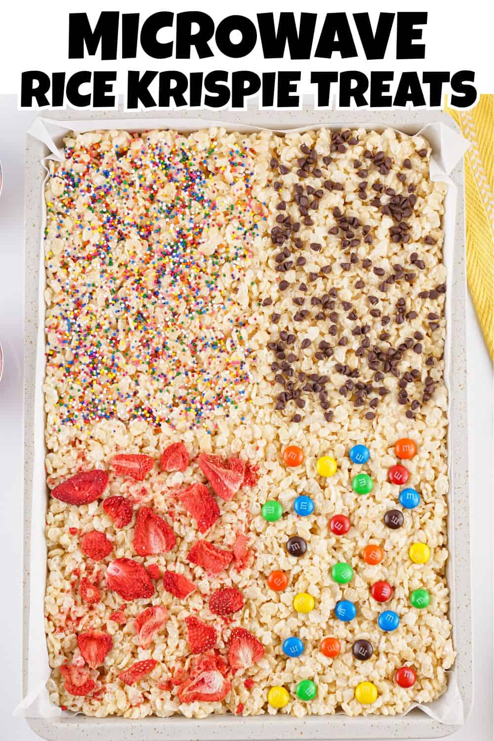 Overhead view of Rice Krispies in a sheet pan with sprinkles, strawberries, chocolate and M & M's Pin.