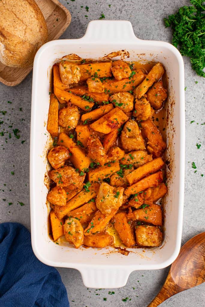 Overhead view of chicken and sweet potatoes in a casserole dish.
