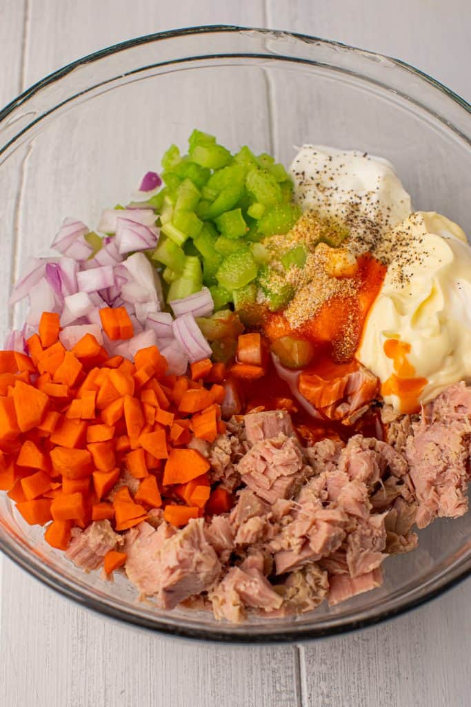 Overhead view of Buffalo chicken salad ingredients in a glass bowl.