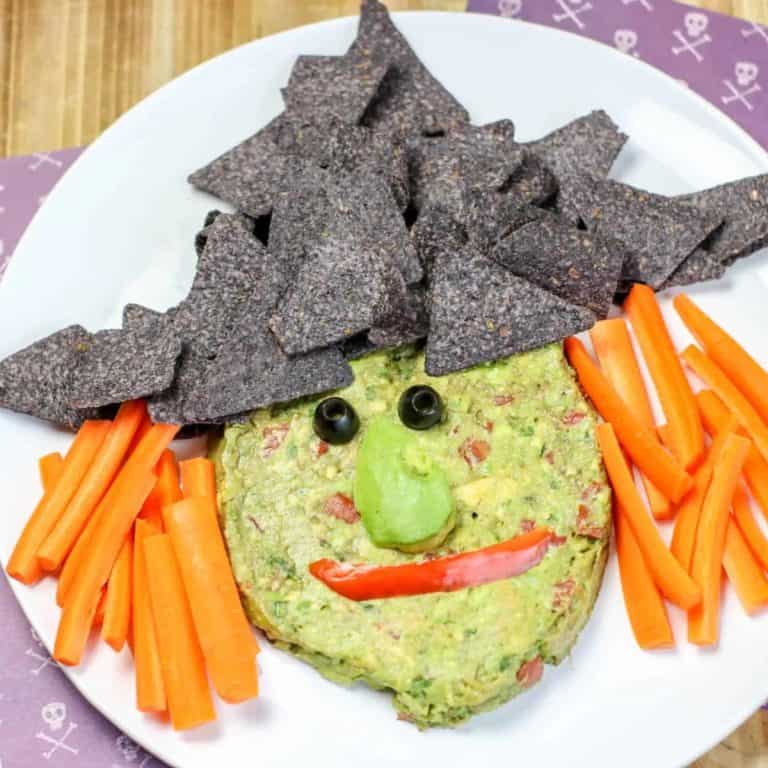 Guacamole Witch with Blue corn tortilla hat and carrot sticks for hair.