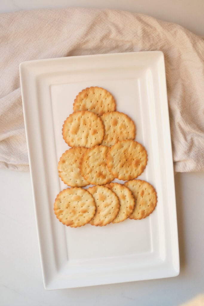 Overhead view of crackers arranged in a tree shape on a white rectangular platter.