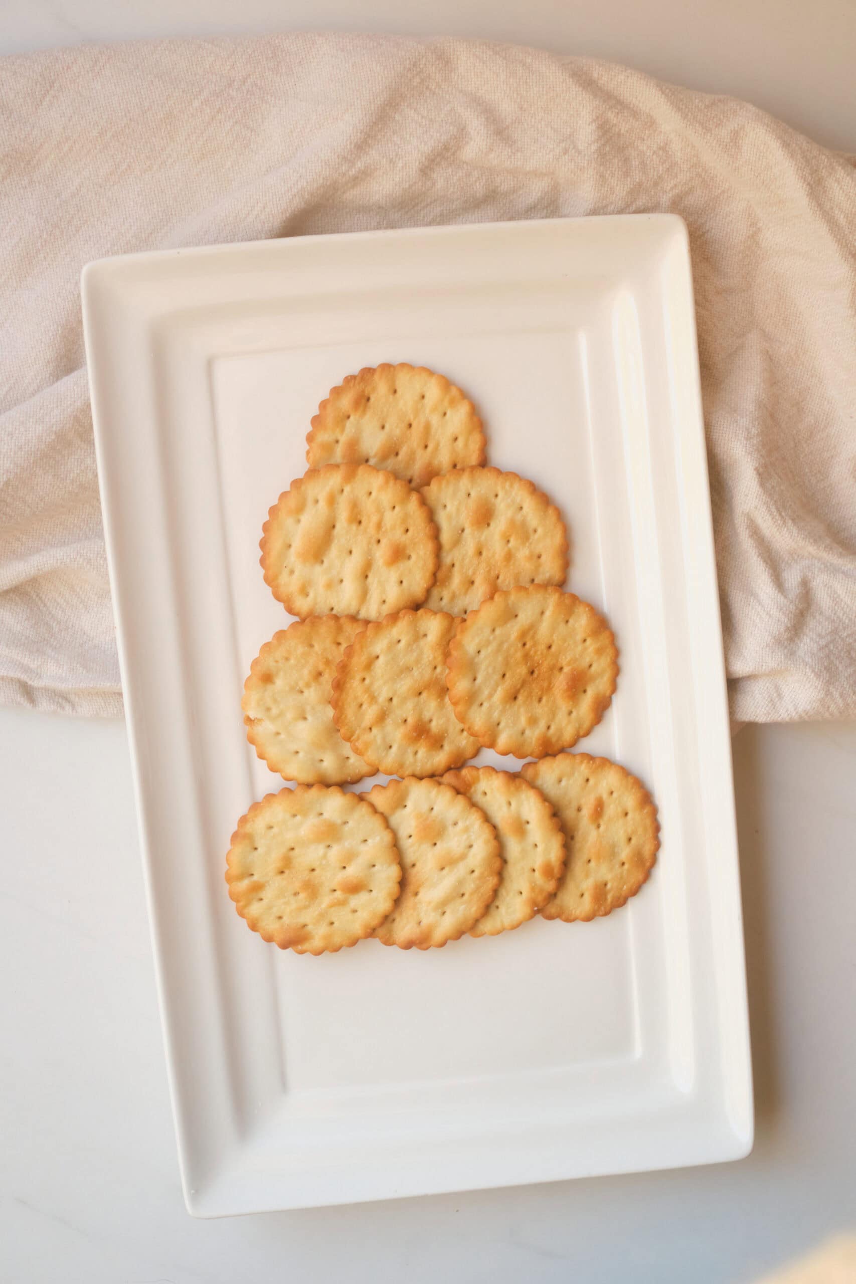 Overhead view of crackers arranged in a tree shape on a white rectangular platter.
