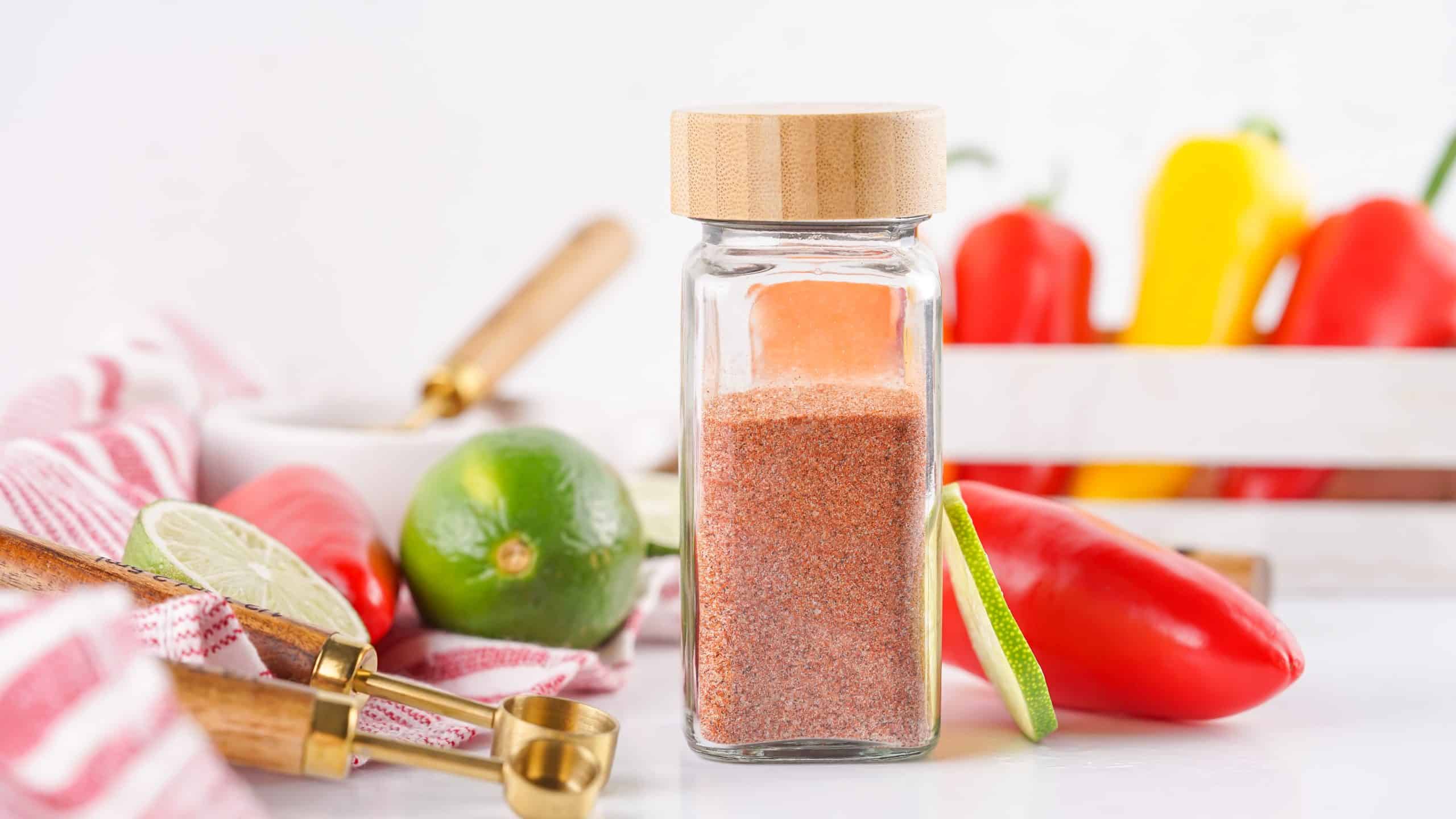 Tajin seasoning in a clear glass spice bottle.