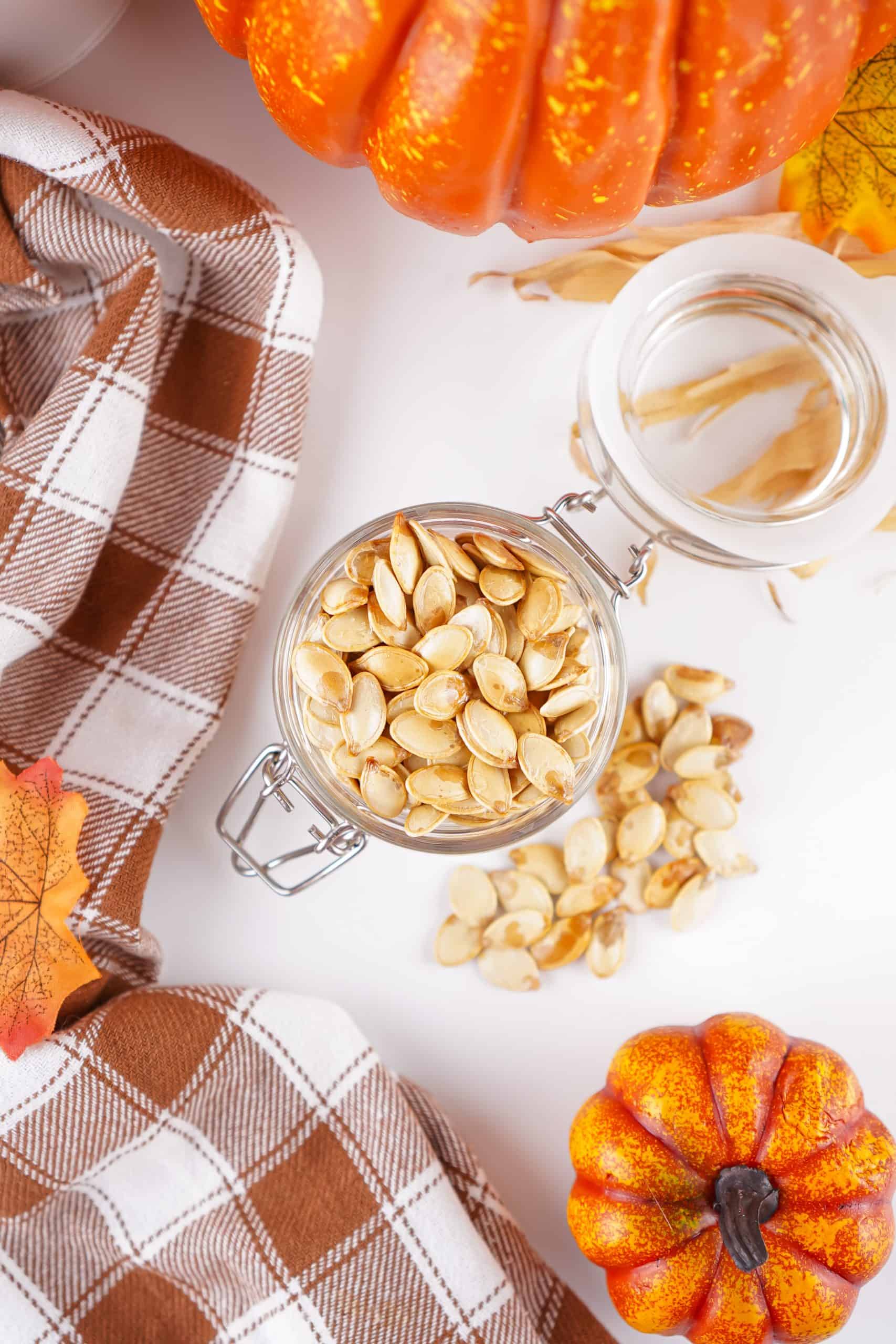 Overhead view of roasted pumpkin seeds in a glass jar.