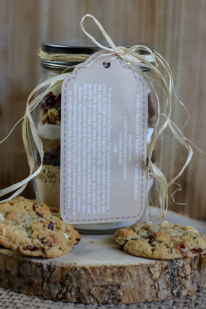 White chocolate cranberry cookie mix in a jar with a gift tag.